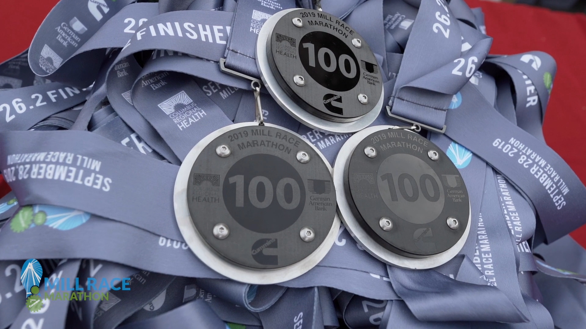 Cummins 100 years promotional medals for the 2019 Mill Race Marathon. Also promoting Columbus Regional Health and German American Bank.